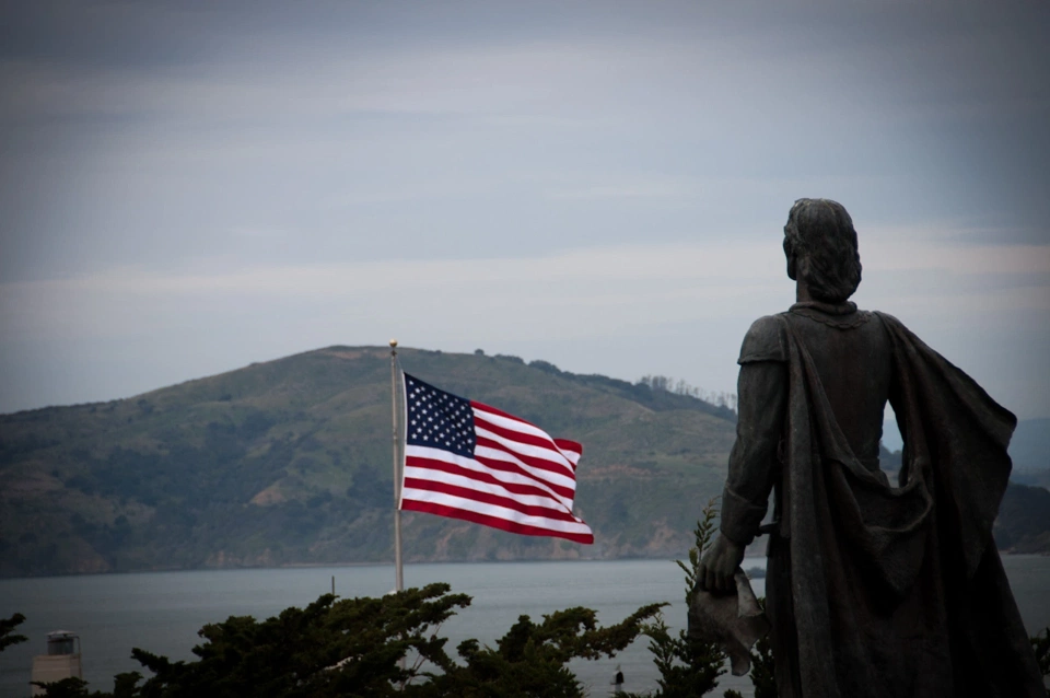 Columbus in front of the US flag.